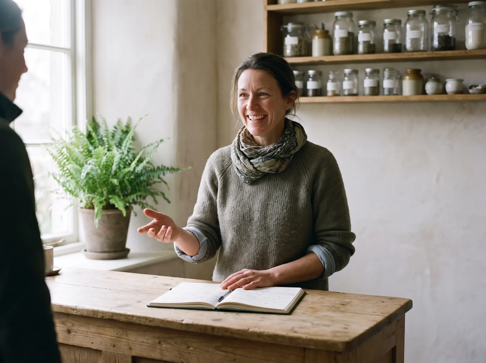 The owner of a small independent business talking with a customer across the counter.
